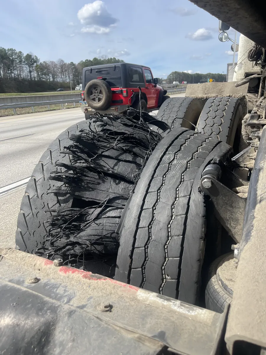 Blown semi truck tire shredded on the roadside