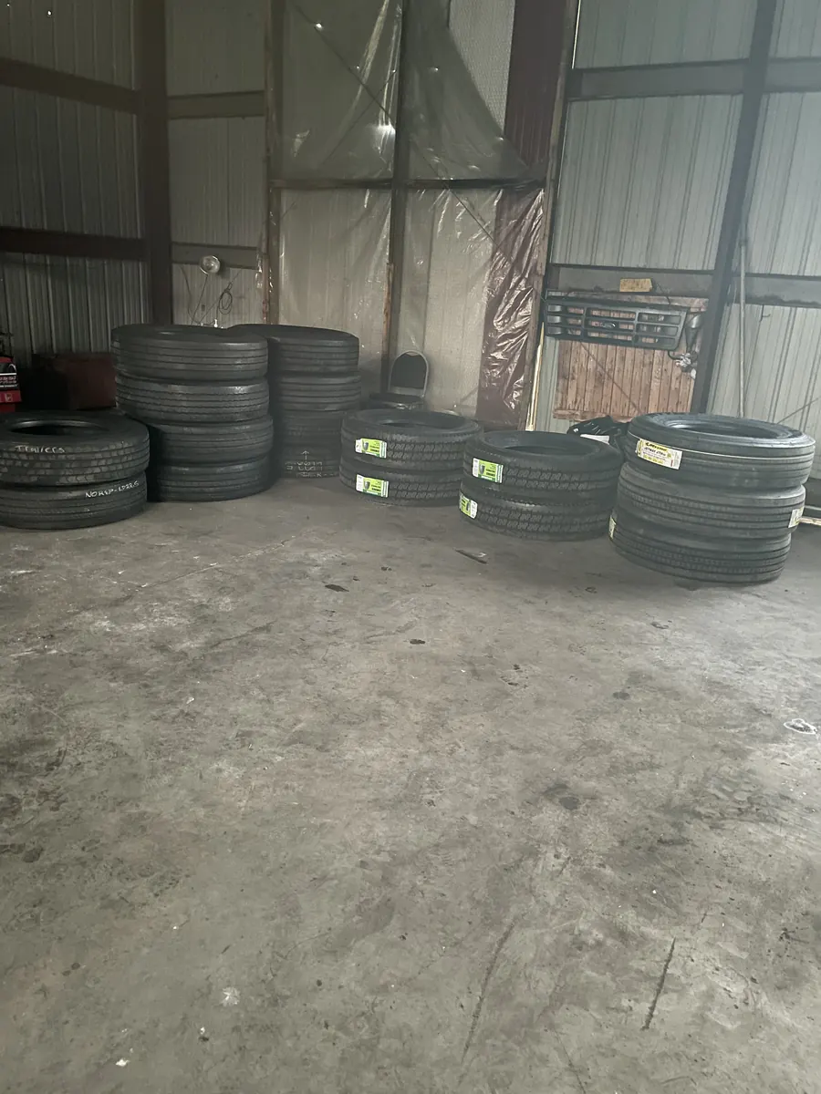 Tagged tire inventory stacked along the shop wall