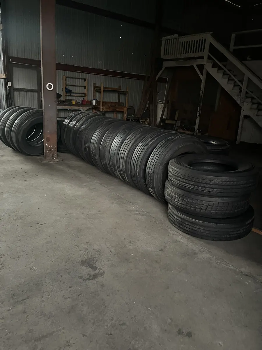 Used tires lined up on the floor inside the shop